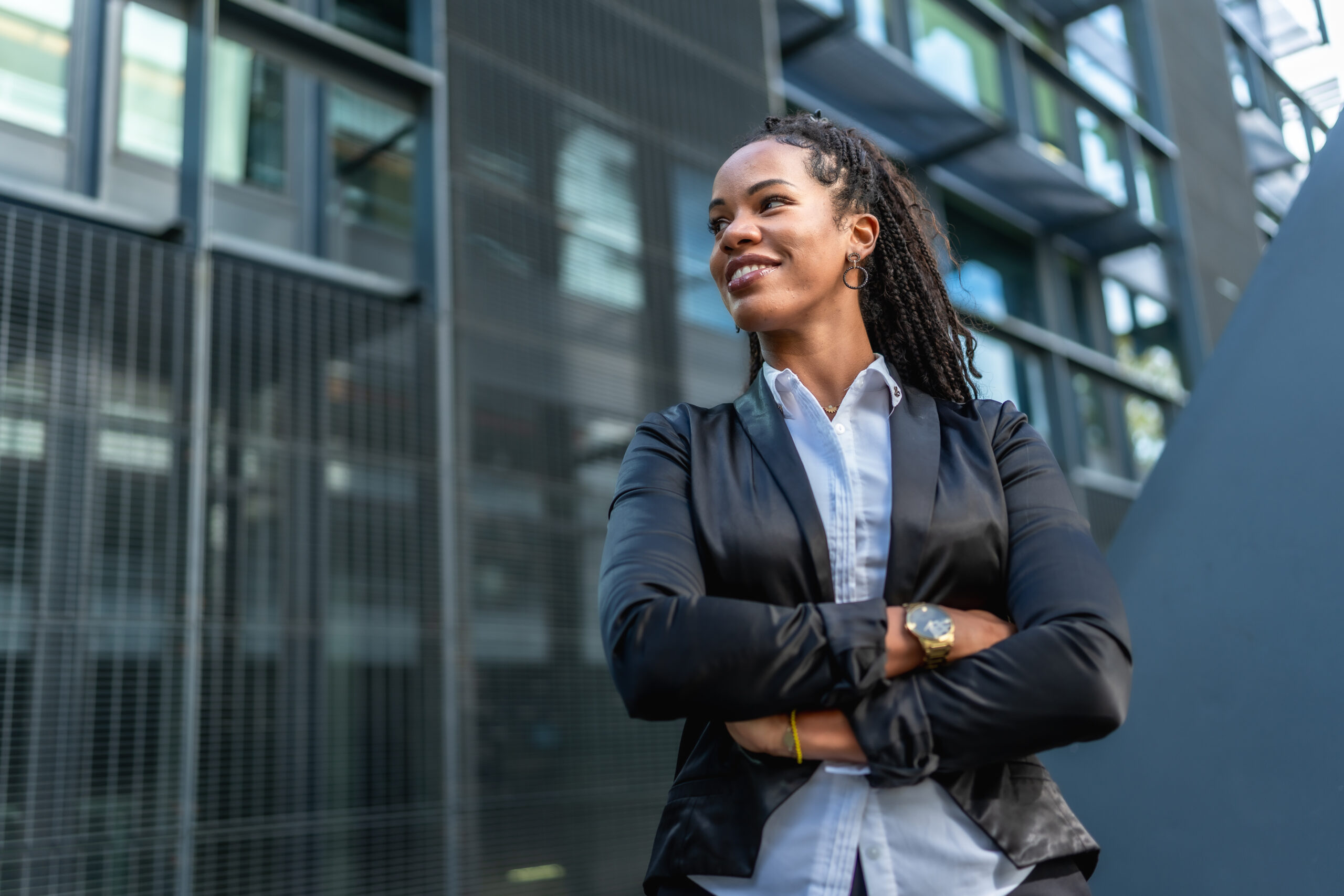 Latin entrepreneur smiling proud standing outside a block office